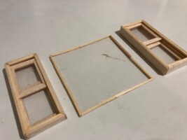Wood sticks are glued into three lines to create sliding windows. Windows